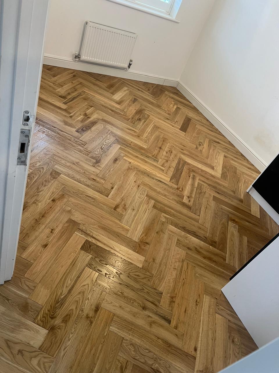 Parket herringbone lisi në derën e dhomës së gjumit