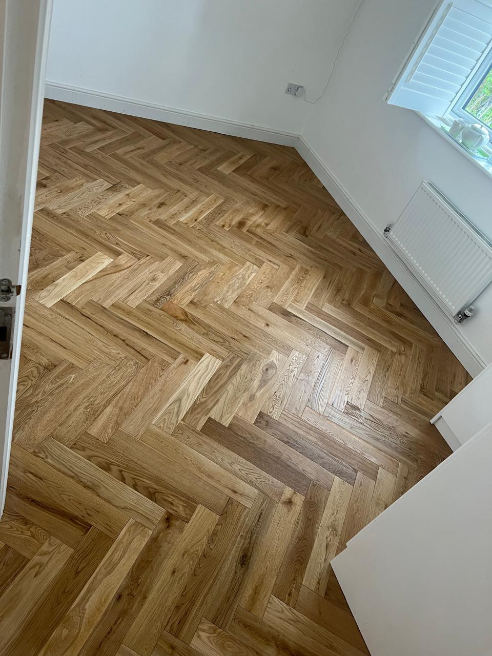 Herringbone lisi në dhomë me dritë dielli dhe radiator