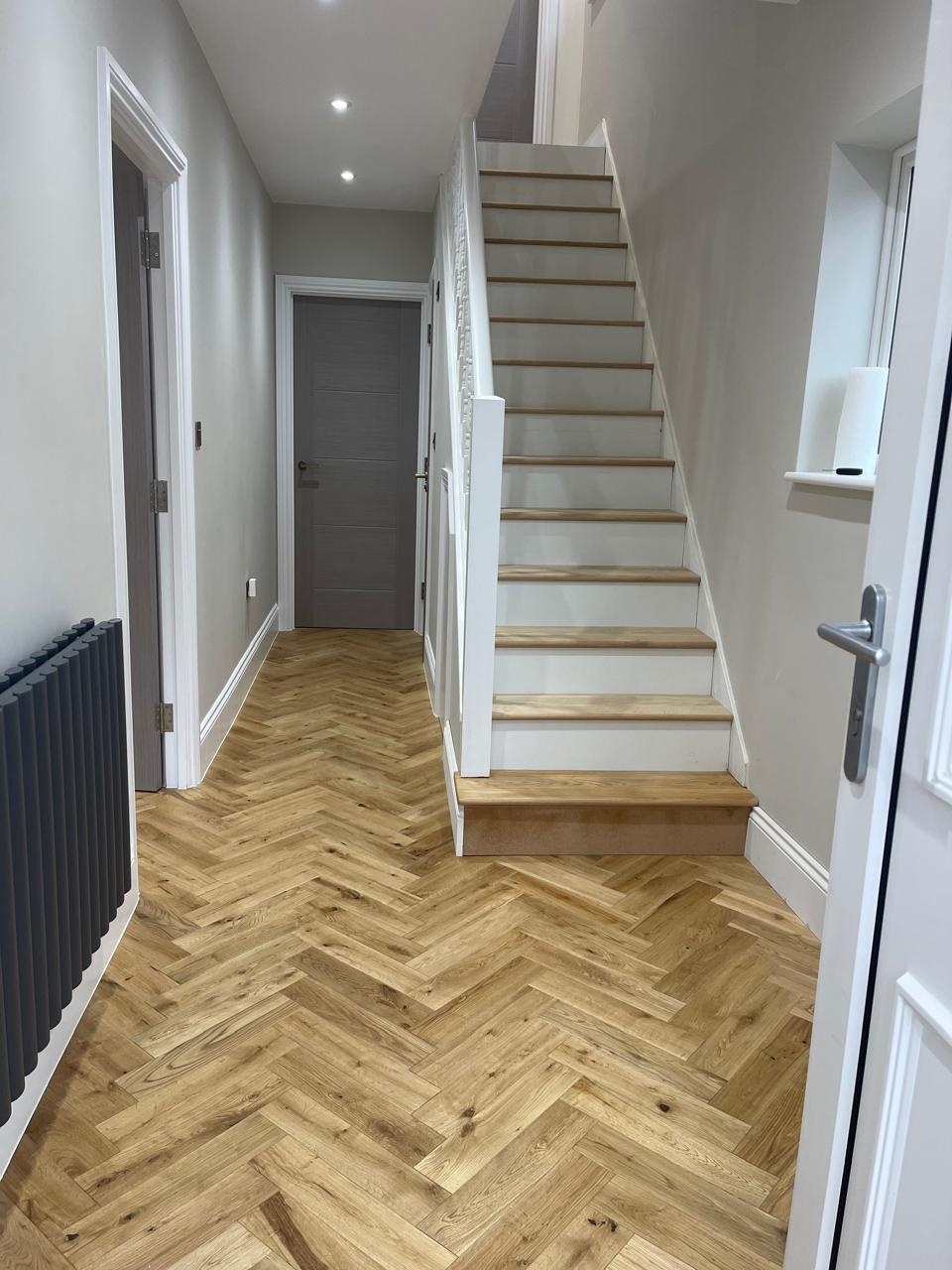 Herringbone lisi në korridor me shkallë druri
