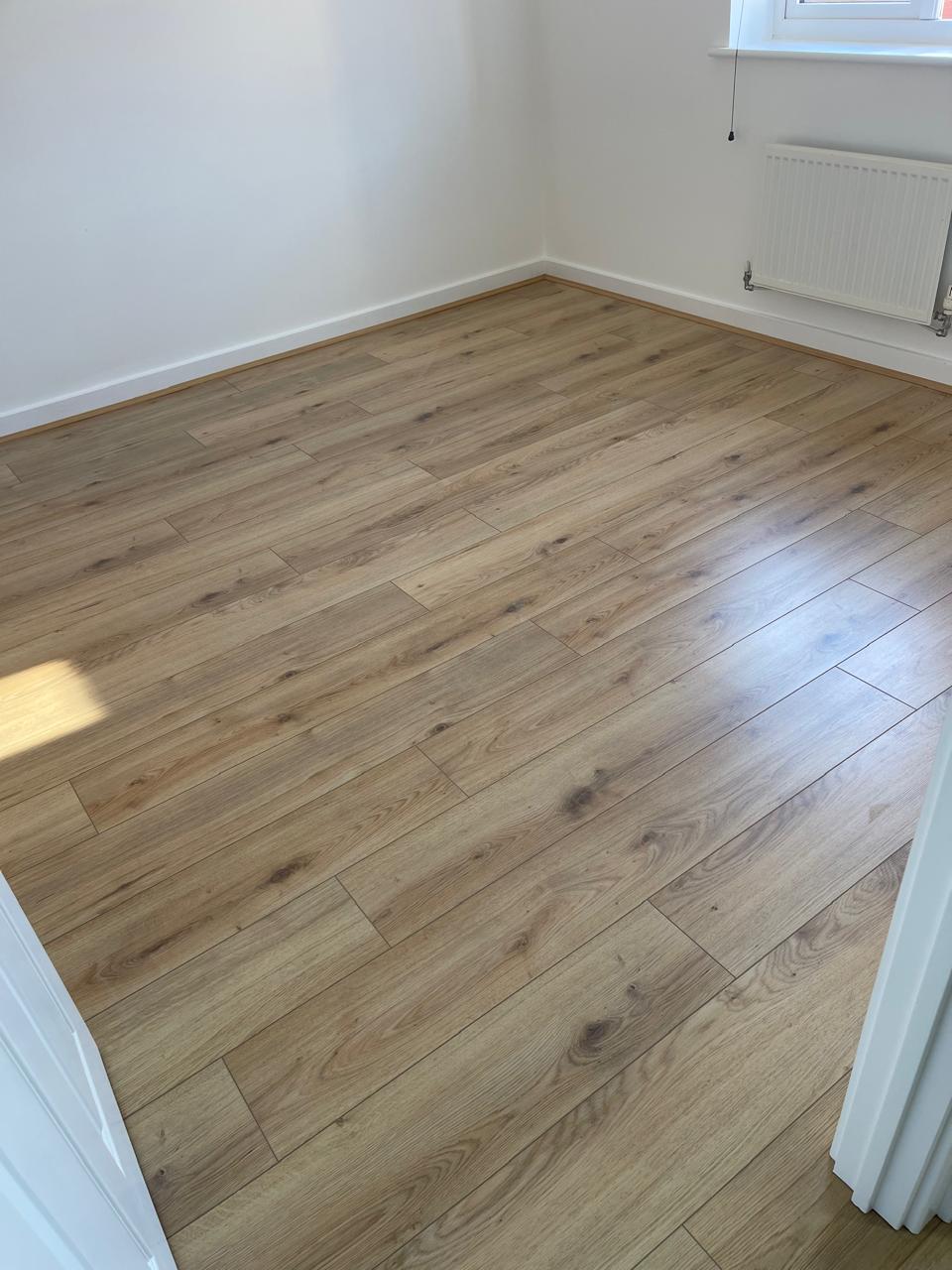 Laminat plank lisi në dhomë gjumi me diell