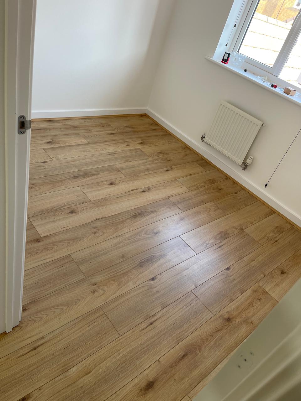 Laminat plank lisi në dhomë gjumi të ndritshme