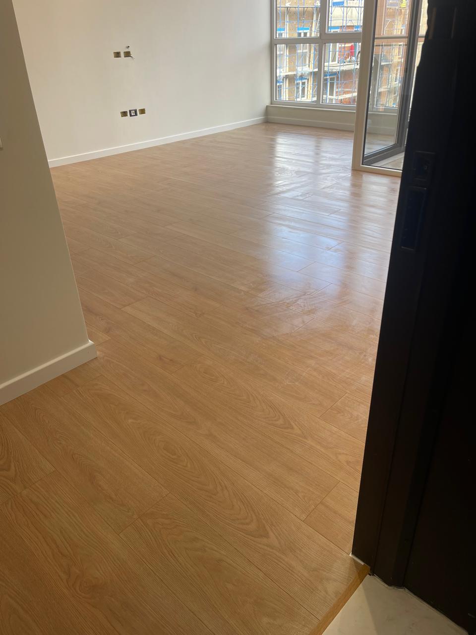 Laminat lisi mjalti në dhomë apartamenti me diell