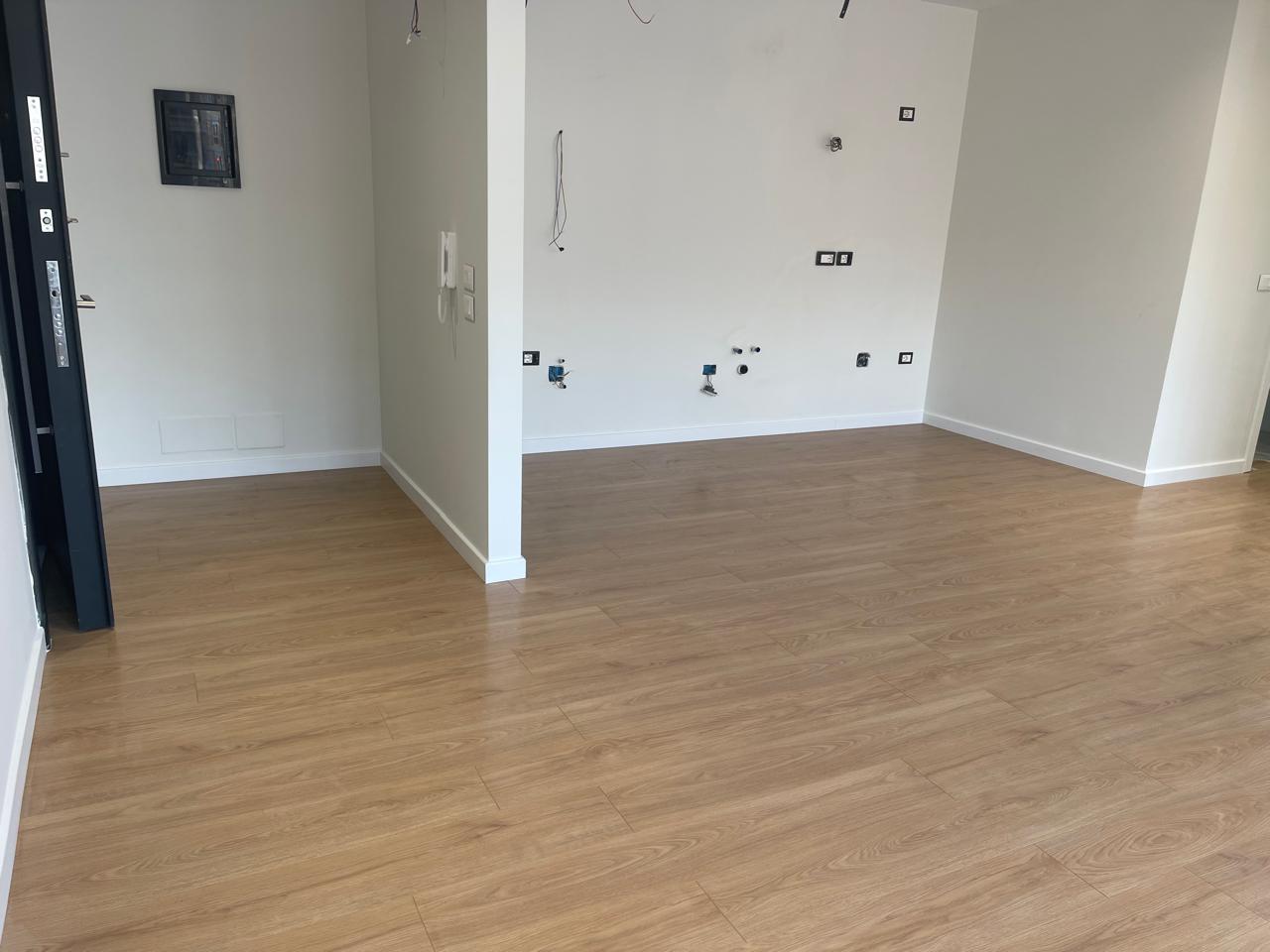 Laminat lisi në hyrjen e apartamentit open-plan