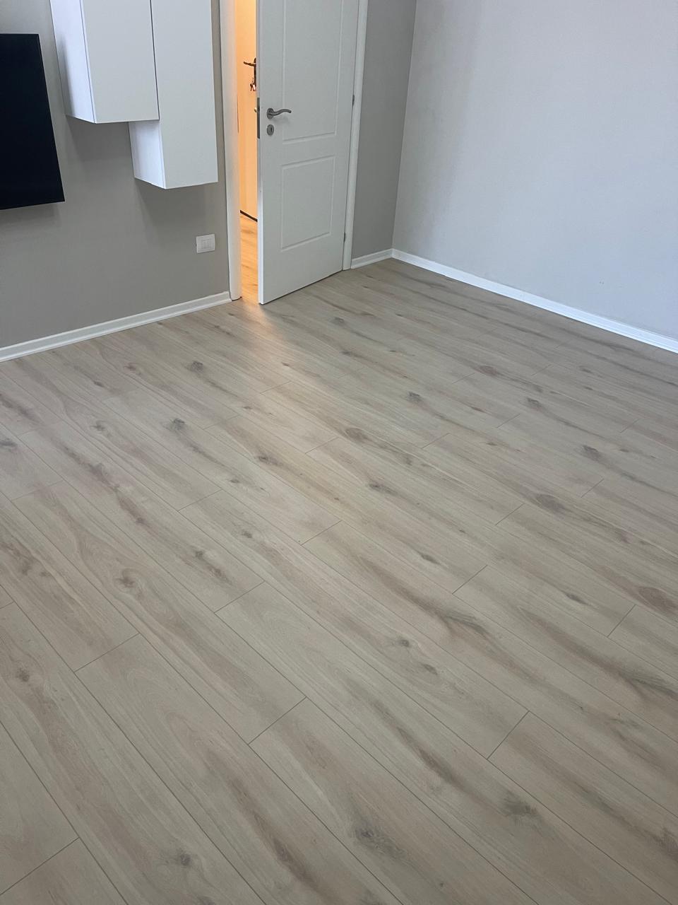 Laminat lisi gri i lehtë në dhomë gjumi moderne
