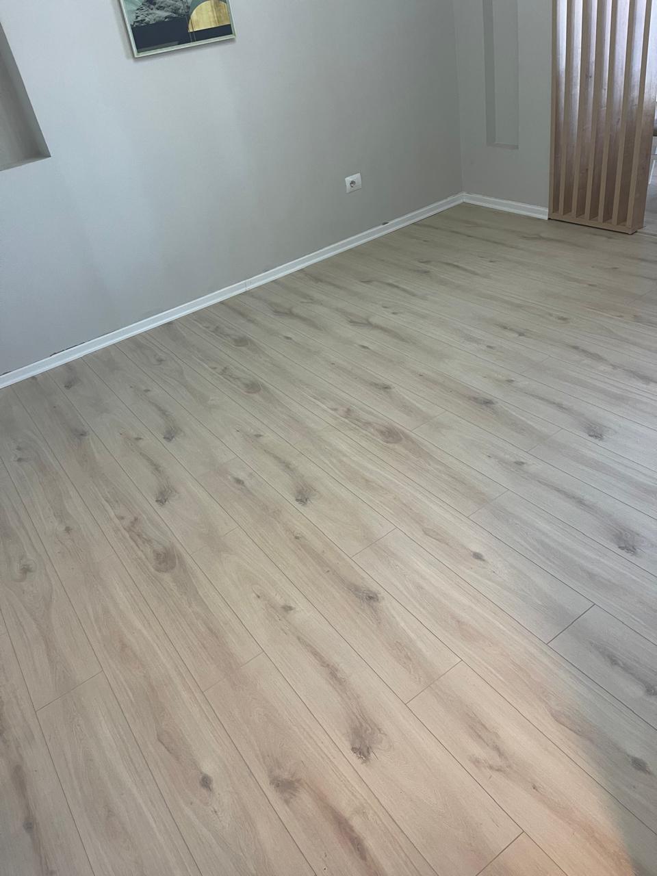 Laminat lisi i lehtë në sallon me ndarës druri