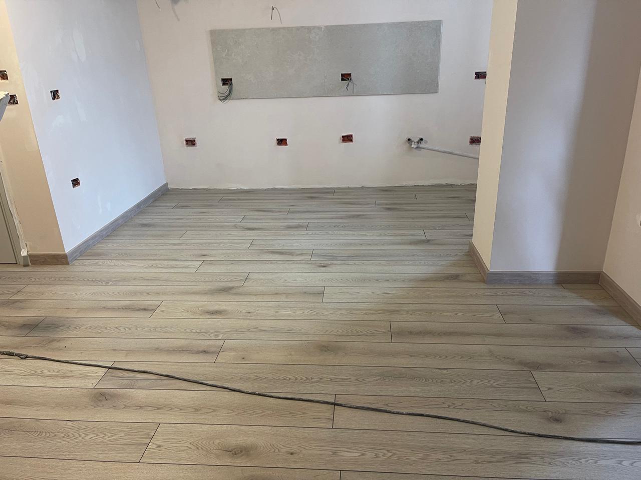 Laminat lisi gri në kuzhinë gjatë ndërtimit