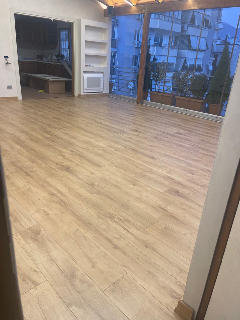Laminat lisi në verandë me mure xhami dhe taracë